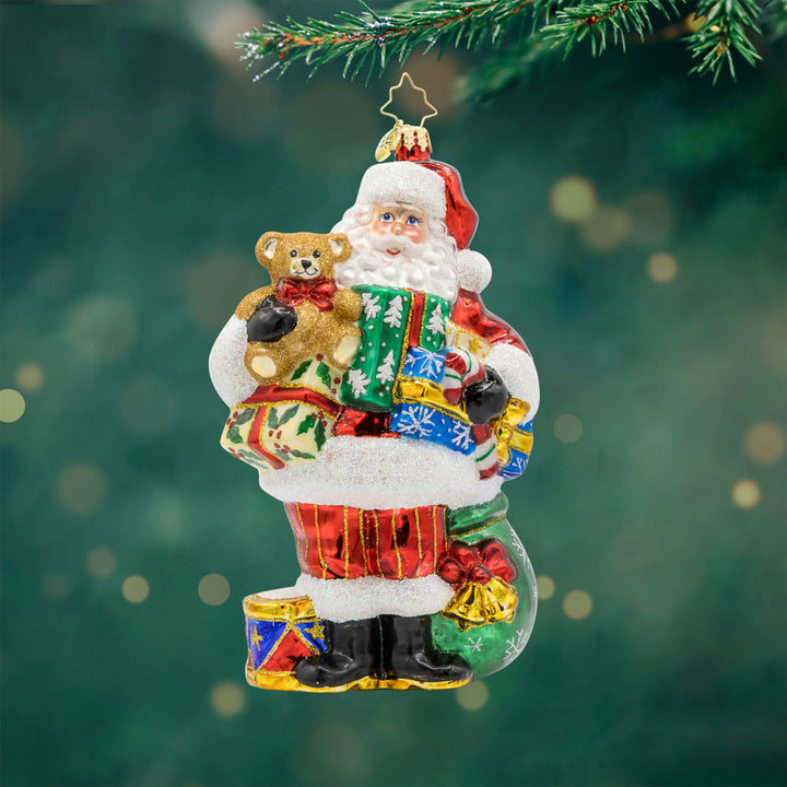 Quite A Handful Santa ornament. Santa holds a teddy bear, candy cane, and a whole bunch of other goodies. View of front. 