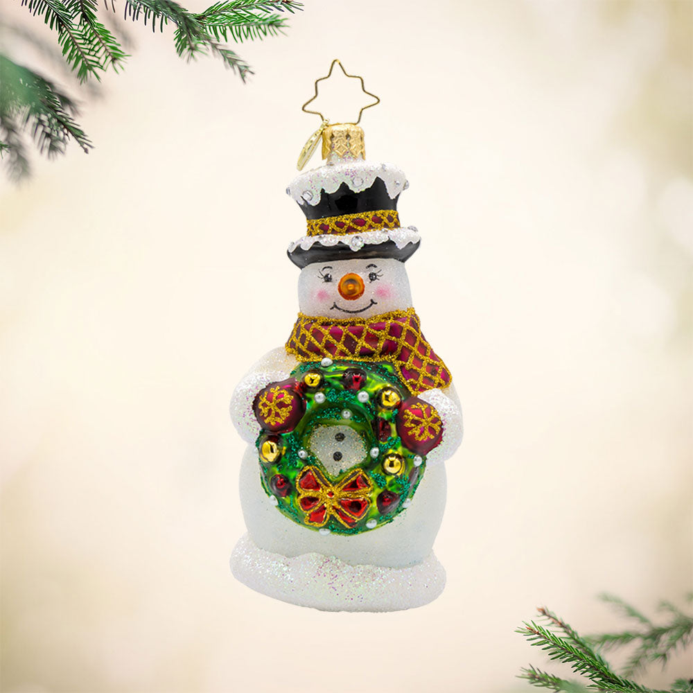 Merry Mittens ornament. A snowman with his wreath-tastic accessory full of red and gold ornaments. View of front. 