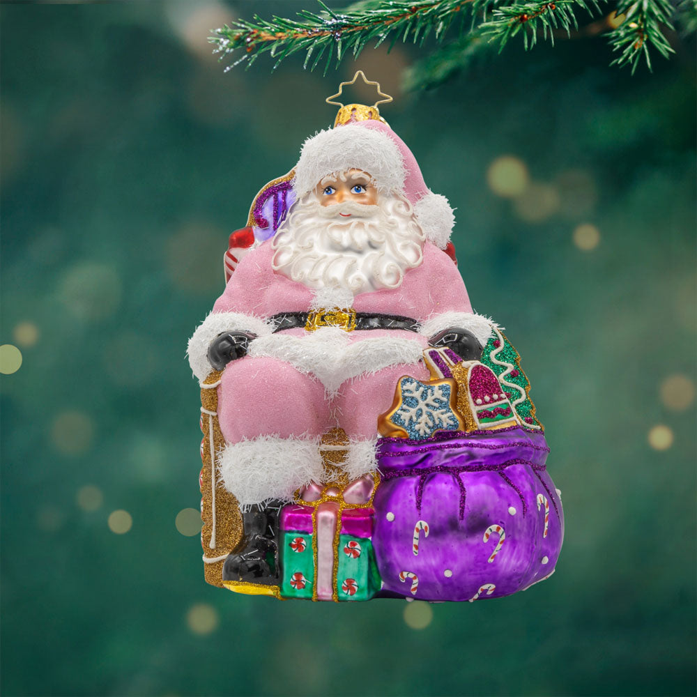 Sweet Tooth Santa ornament. Features Santa in a pink suit surrounded by candy canes, cookies, and other delicious treats. View of front.