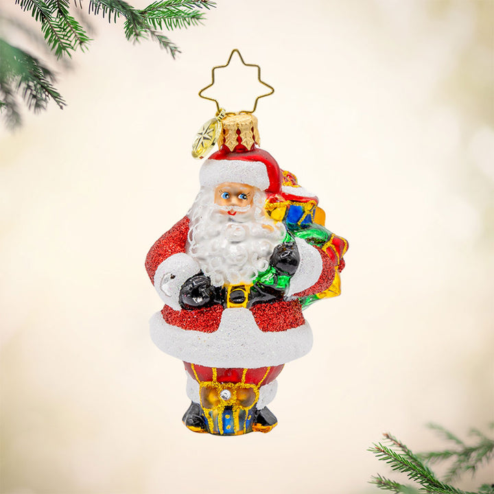 Starlit Holiday Delivery Gem ornament. Santa is holding a large green gift sack of presents. View of front. 