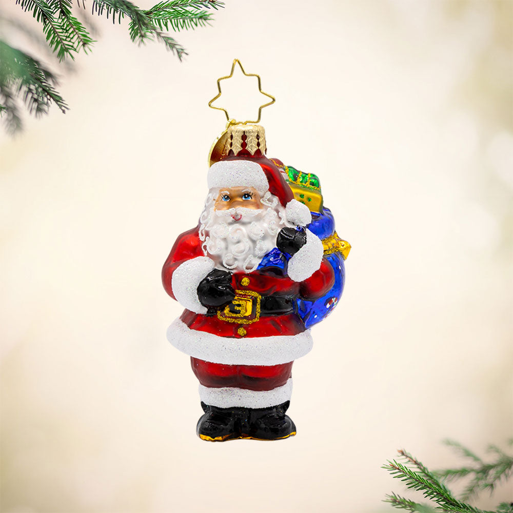 Presents on His Mind Gem ornament. Dressed in red, Santa carries a sack brimming with presents. View of front.