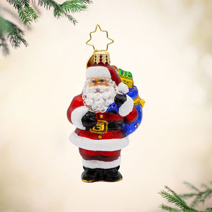 Presents on His Mind Gem ornament. Dressed in red, Santa carries a sack brimming with presents. View of front.