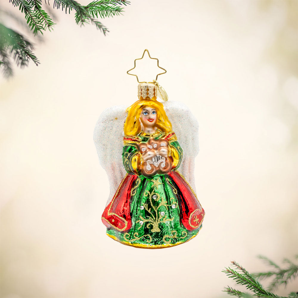 Heavenly Harpist Gem Ornament. This angel wears a green and red dress flecked with gold. Harp in hand and shimmering white wings behind her. View of front. 