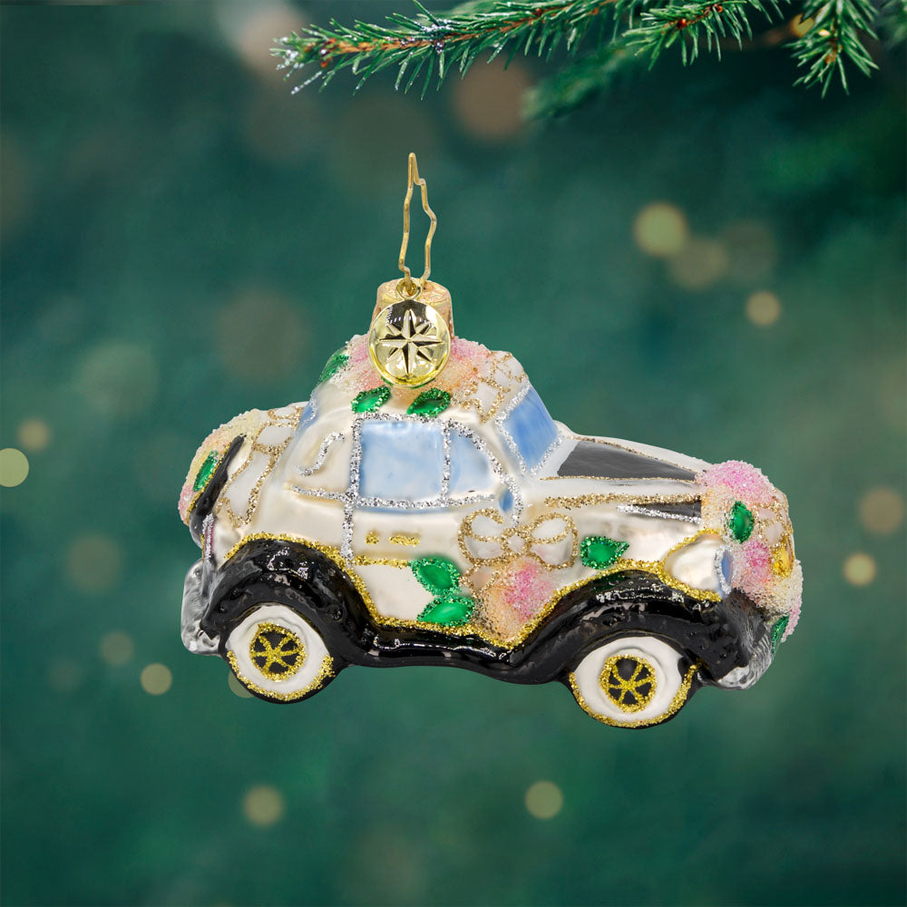 Wedding Day Wheels Gem ornament. A black and white car adorned with pink flowers and white bows. View of front. 