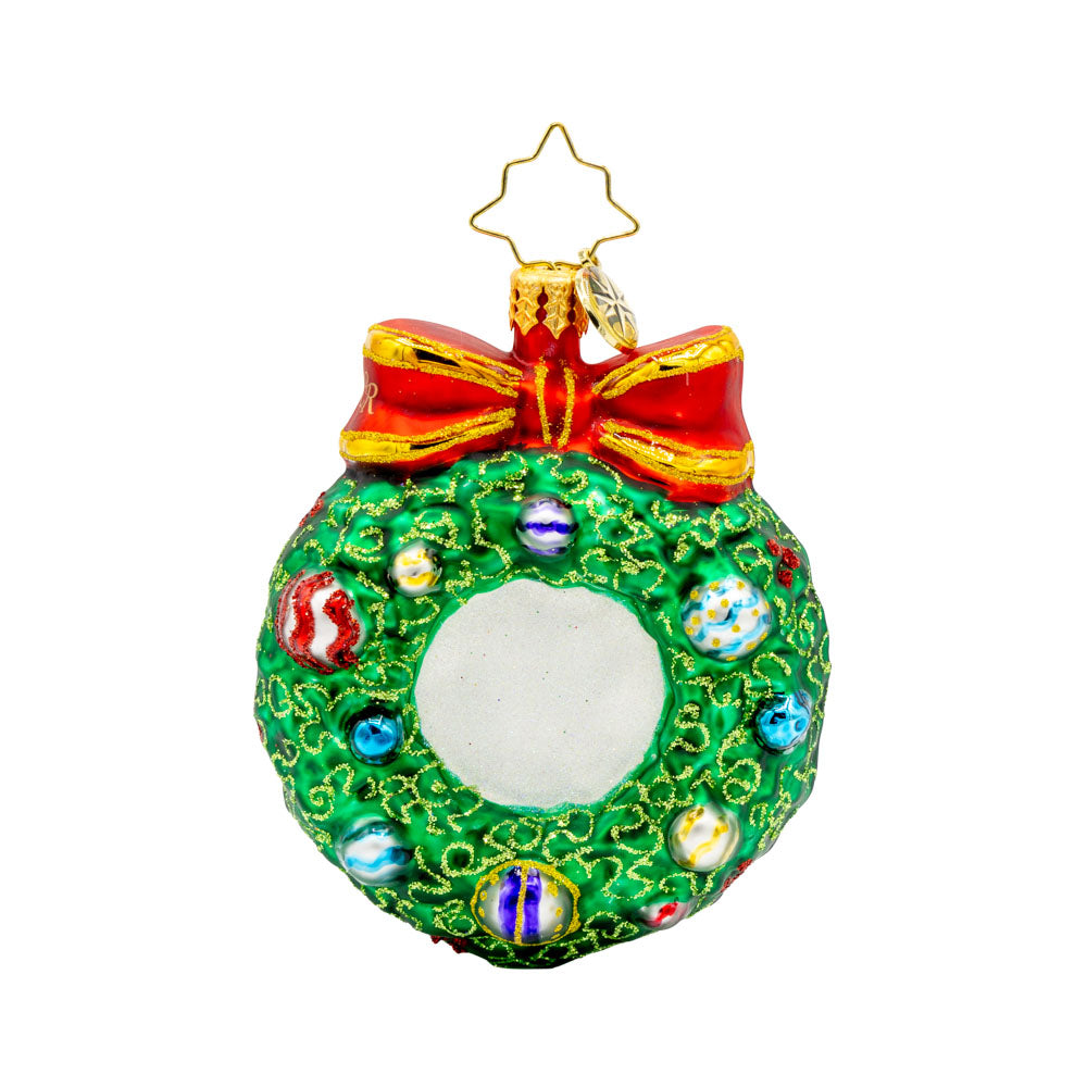 Smiling Through 2025 Gem. Santa is seen popping through the center of a festive wreath. Ornaments dated "2025" hang next to him. View of back.