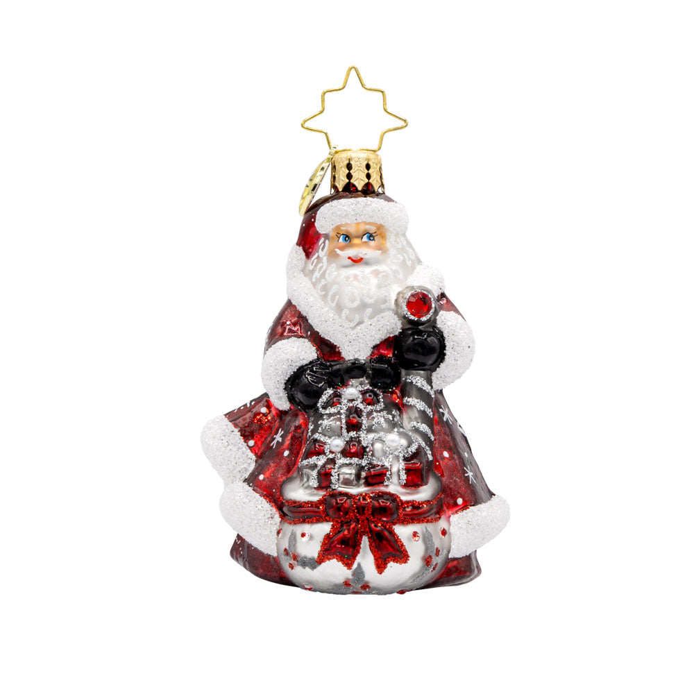 Frosty Fawn Santa Gem ornament. Santa is donned in red and silver, holding a scepter with a pile of gifts in a gift sack before him. View of front. 