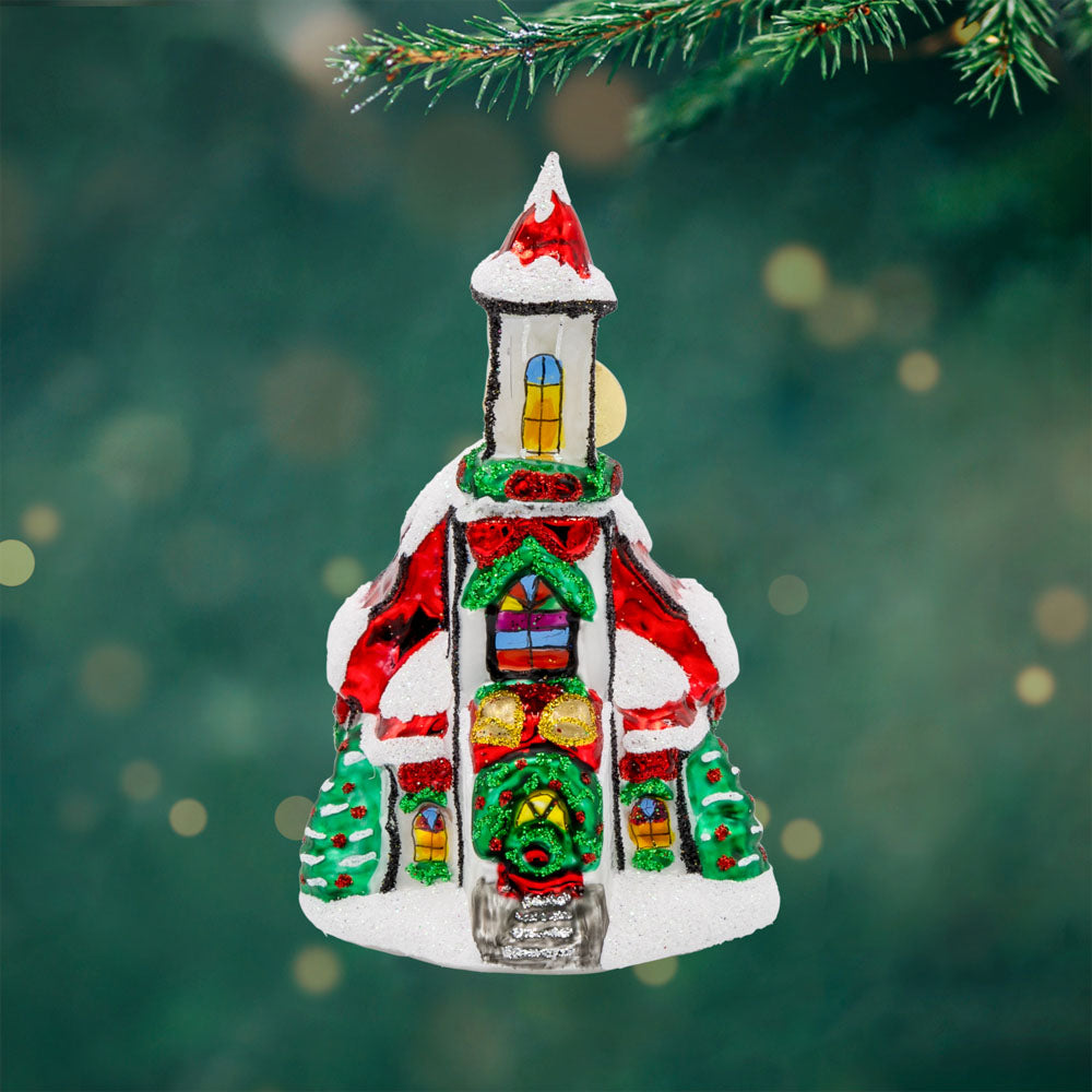Holly Bell Chapel Gem ornament. A snow-covered chapel with a red roof adorned with wreathes galore. View of front. 