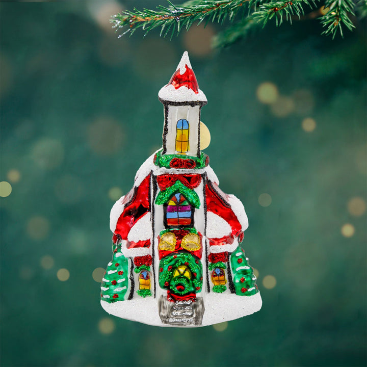 Holly Bell Chapel Gem ornament. A snow-covered chapel with a red roof adorned with wreathes galore. View of front. 