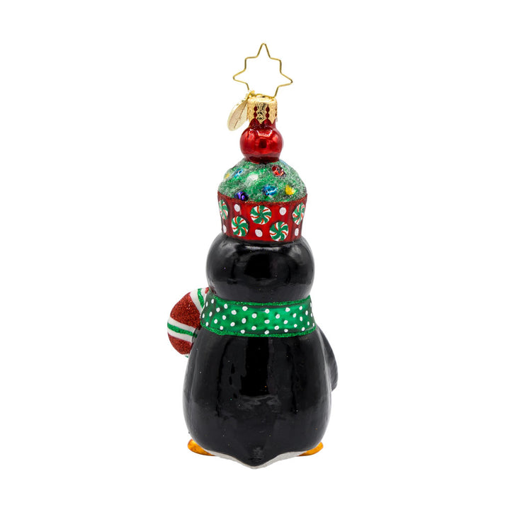 Cupcake Clad Penguin ornament. This penguin wears a cupcake hat topped with sprinkles and a festive candy cane in hand. View of back.