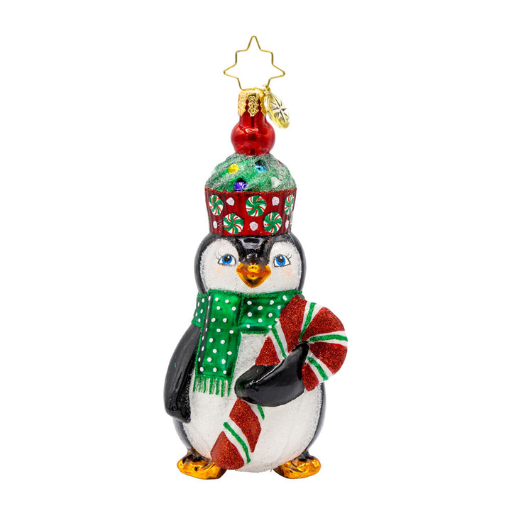 Cupcake Clad Penguin ornament. This penguin wears a cupcake hat topped with sprinkles and a festive candy cane in hand. View of front. 