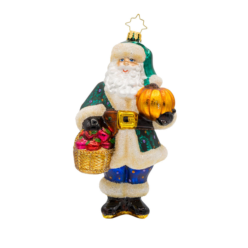 Enchanted Evergreen Santa ornament. Dressed in his finest fall attire, he has a basket of apples in one hand and a pumpkin in the other. View of front. 