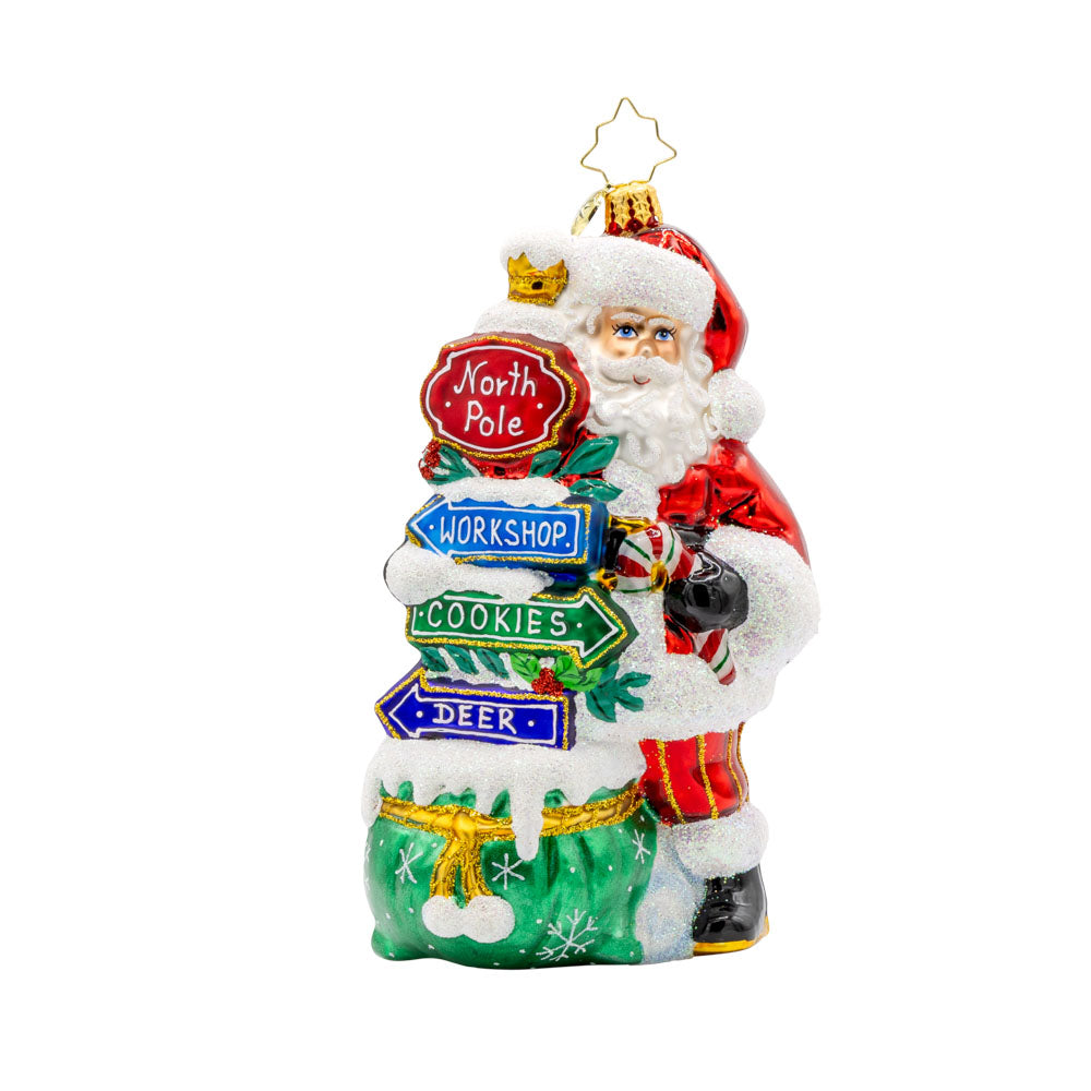 Sign of the Season Santa ornament. Santa stands next to his festive signs that will lead you to the North Pole and beyond. View of front. 