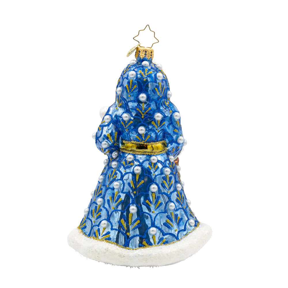 Gilded Grandeur Santa ornament. Dressed in a blue satin coat adorned with intricate designs, paired with his shiny staff and a lantern that casts a warm glow. View of back.