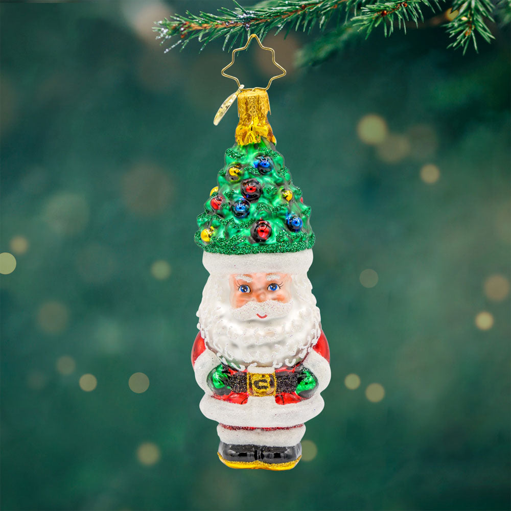 Treetop Tidings ornament. Santa trades his red hat for a Christmas tree, complete with ornaments and a star on top. View of front. 