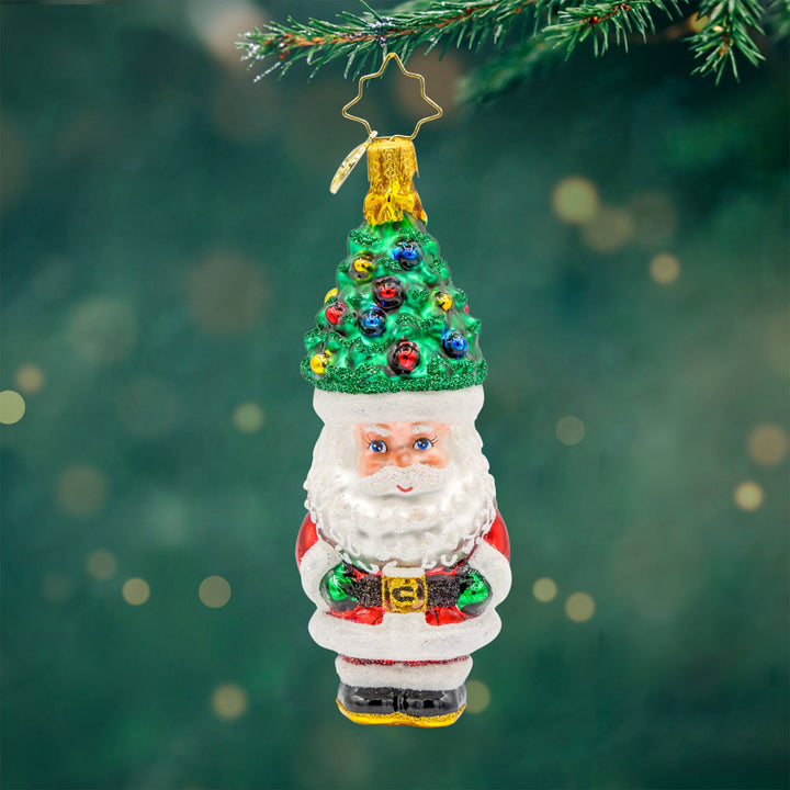Treetop Tidings ornament. Santa trades his red hat for a Christmas tree, complete with ornaments and a star on top. View of front. 