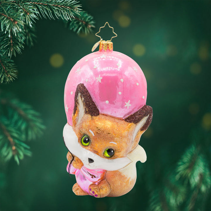 Pink Foxy Float ornament. Featuring a baby fox holding onto a pink balloon. View of front. 