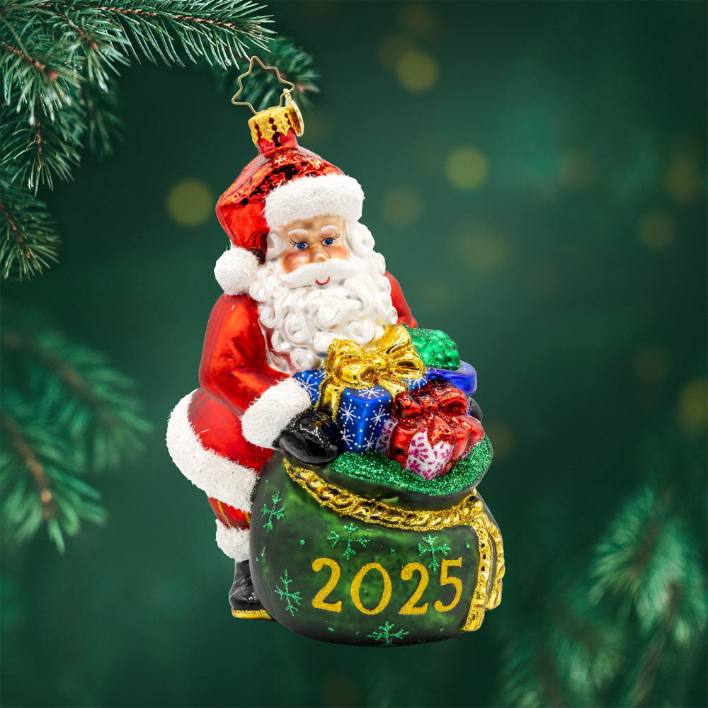 Santa's Yearly Gift Drop ornament. Santa holds an overflowing gift bag dated "2025." View of front.