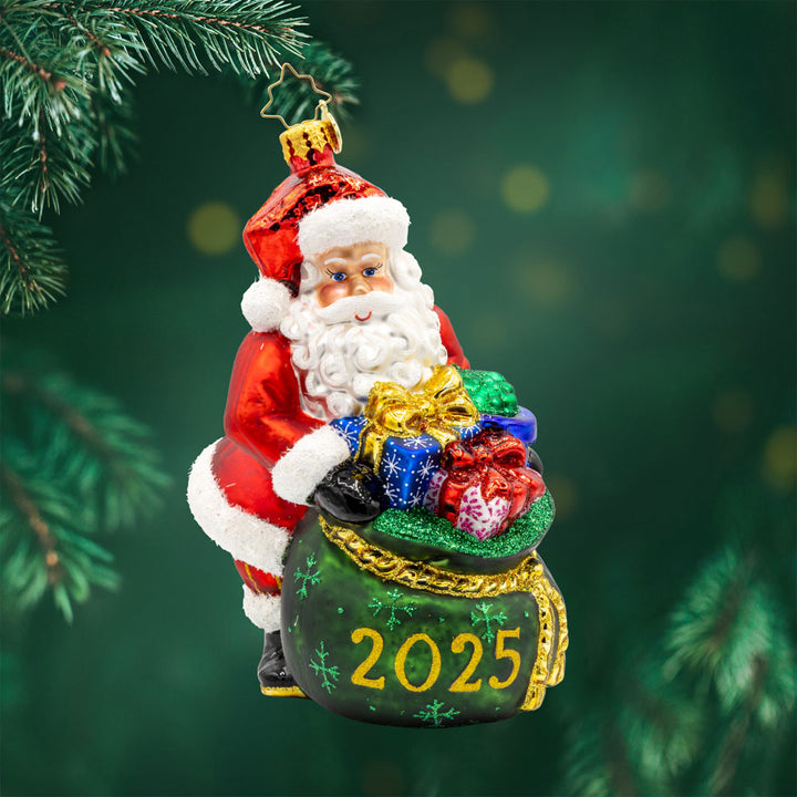 Santa's Yearly Gift Drop ornament. Santa holds an overflowing gift bag dated "2025." View of front.