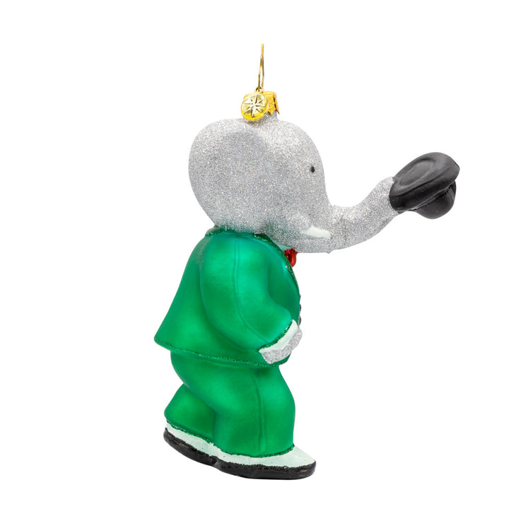 King Babar ornament. Babar dons his green suit, holding a top hat with his trunk. View of left side.