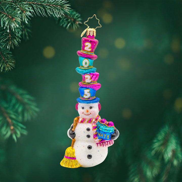 Hat-Tastic Snowman 2025 ornament. Featuring a snowman wearing a stack of hats with "2025" written on them. View of front. 