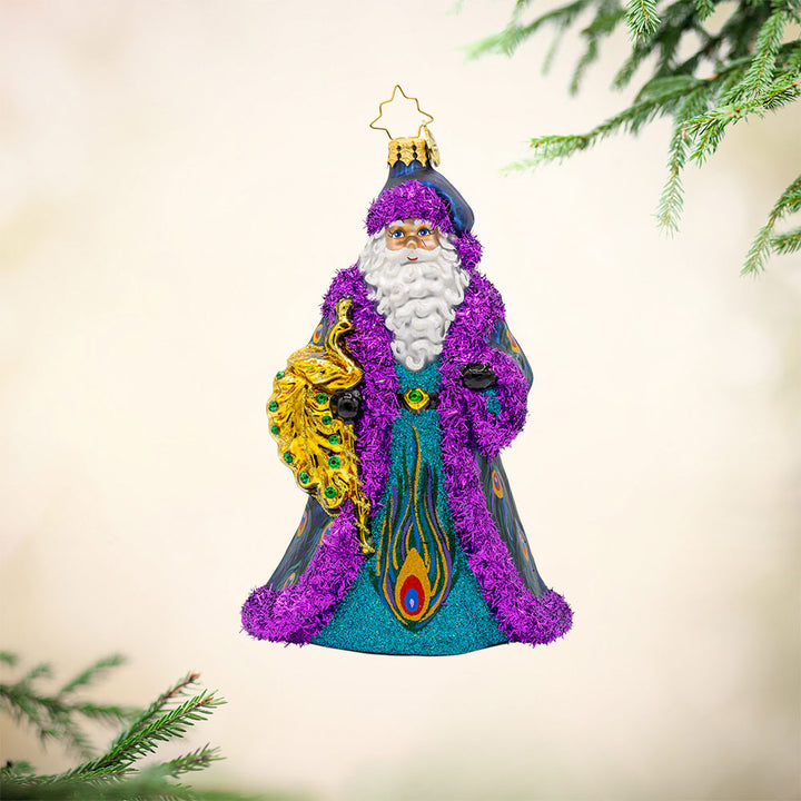 Peacock Splendor ornament. Santa is draped in a luxurious, peacock-feather-inspired coat and holding an ornate peacock staff. View of front.