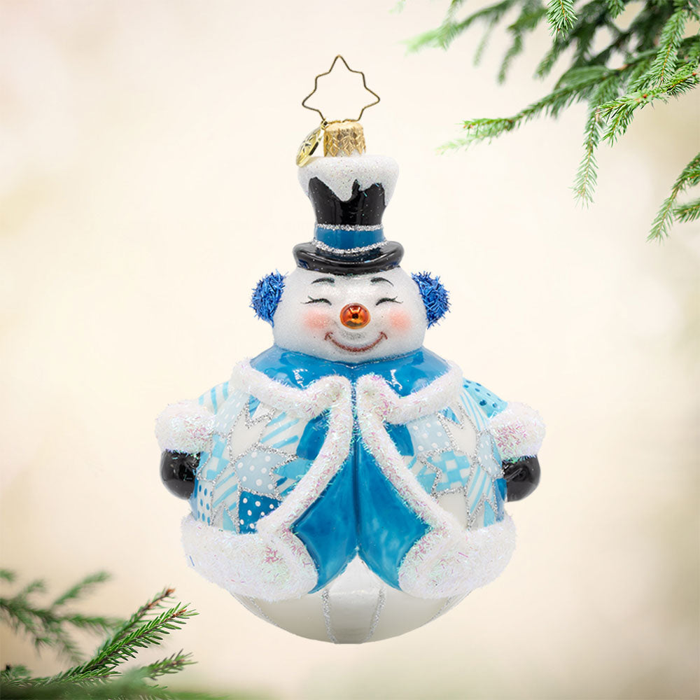 Quilted Jolly Snowman ornament. Bundled up in a quilted jacket, with glittery earmuffs and a charming frosty face. View of front. 