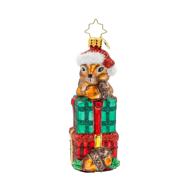 Chipper Cheer ornament. A chipmunk sits atop a stack of gifts with an acorn in hand. View of front.