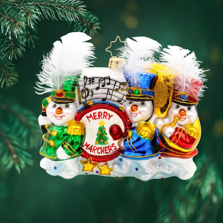 Musical March ornament. Our trio of cheerful snowmen donned in marching band outfits and instruments are ready to serenade you with festive tunes. View of front. 