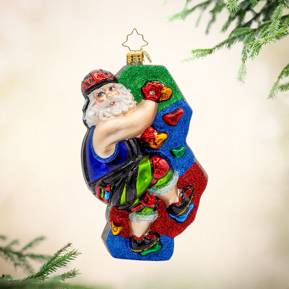 Climbin' Claus ornament. Santa scales colorful climbing holds clad in his climbing gear. View of front.
