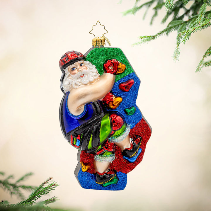 Climbin' Claus ornament. Santa scales colorful climbing holds clad in his climbing gear. View of front.