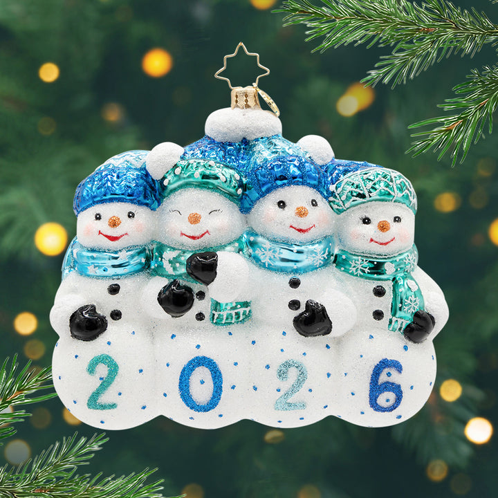 2026: Our Snowiest Year Yet!. Ornament of 4 snowman in matching blue hats and scarfs with the year 2026. View of front
