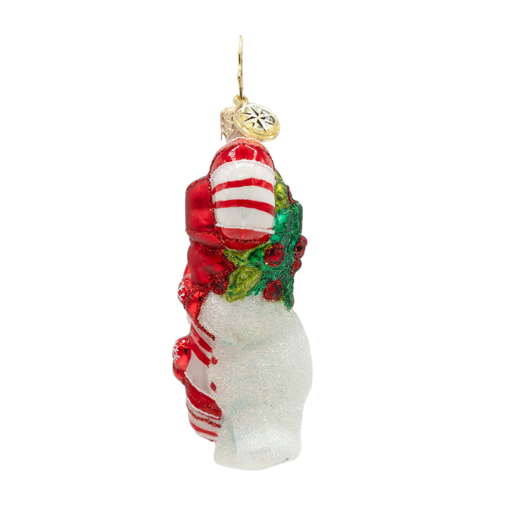 Side of a snowman ornament of a candy cane held by a white snowman with red gloves on a white background