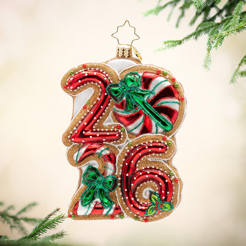 Sweet Start to 2026. Ornament of the year 2026 in peppermint colors and white polka dots with three green bows and gold outlining. View of front