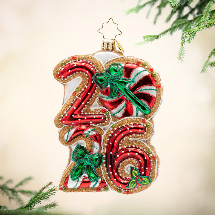 Sweet Start to 2026. Ornament of the year 2026 in peppermint colors and white polka dots with three green bows and gold outlining. View of front