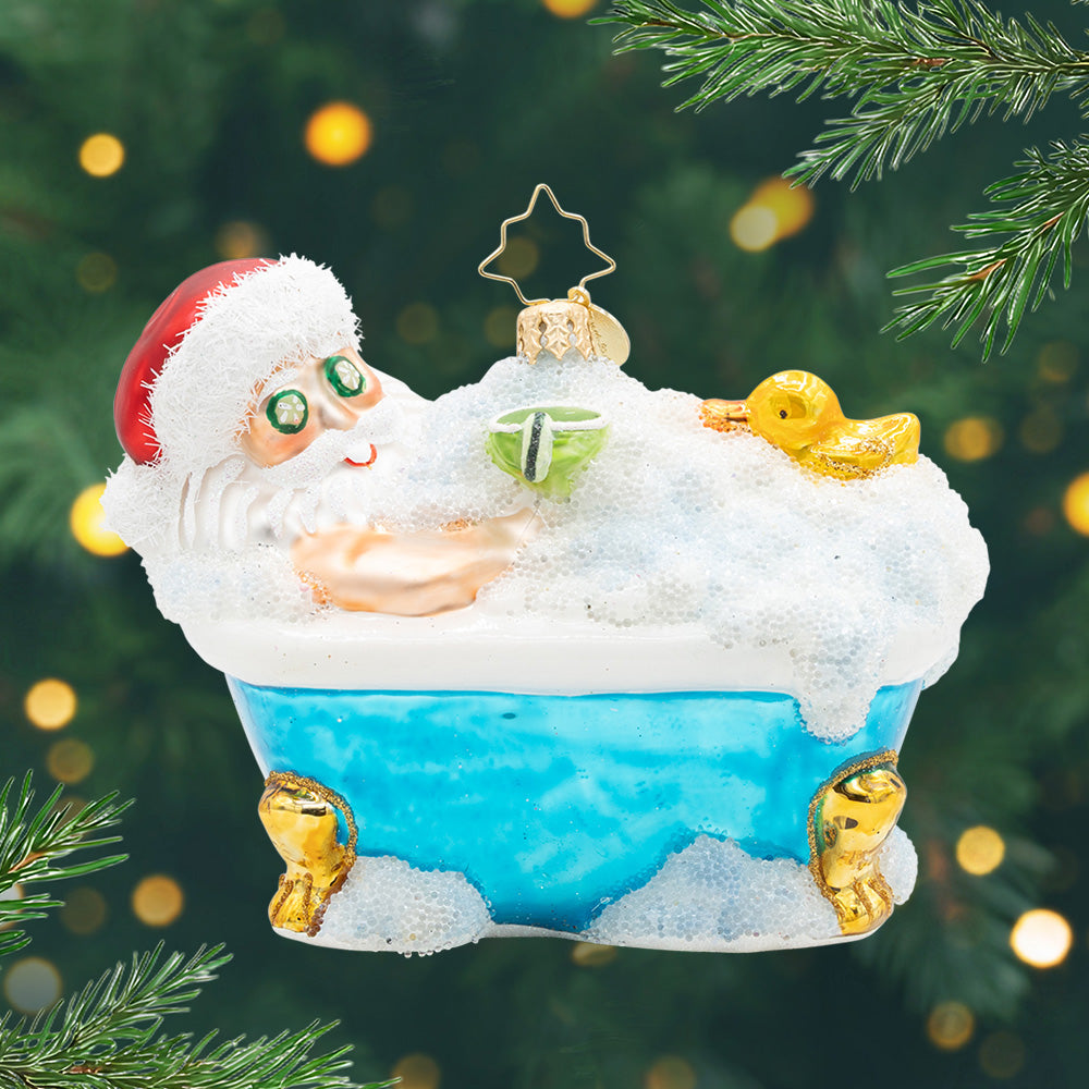 Merry Me Time. Ornament of Santa in a blue tub covered in sparkly bubbles and a drink in hand. View of front