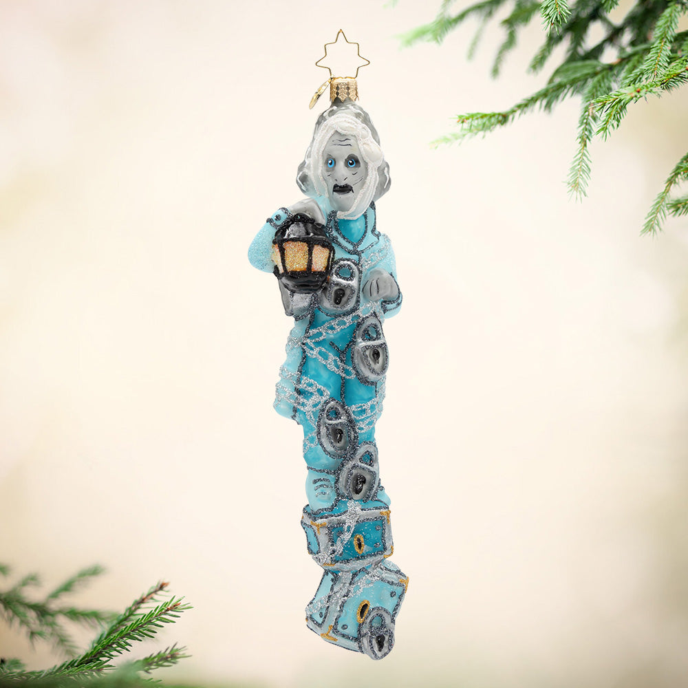 Snowy and the Cardinals Gem. Ornament of Jacob Marley in q blue suit while wrapped in silver chains and holding a lantern. View of front.