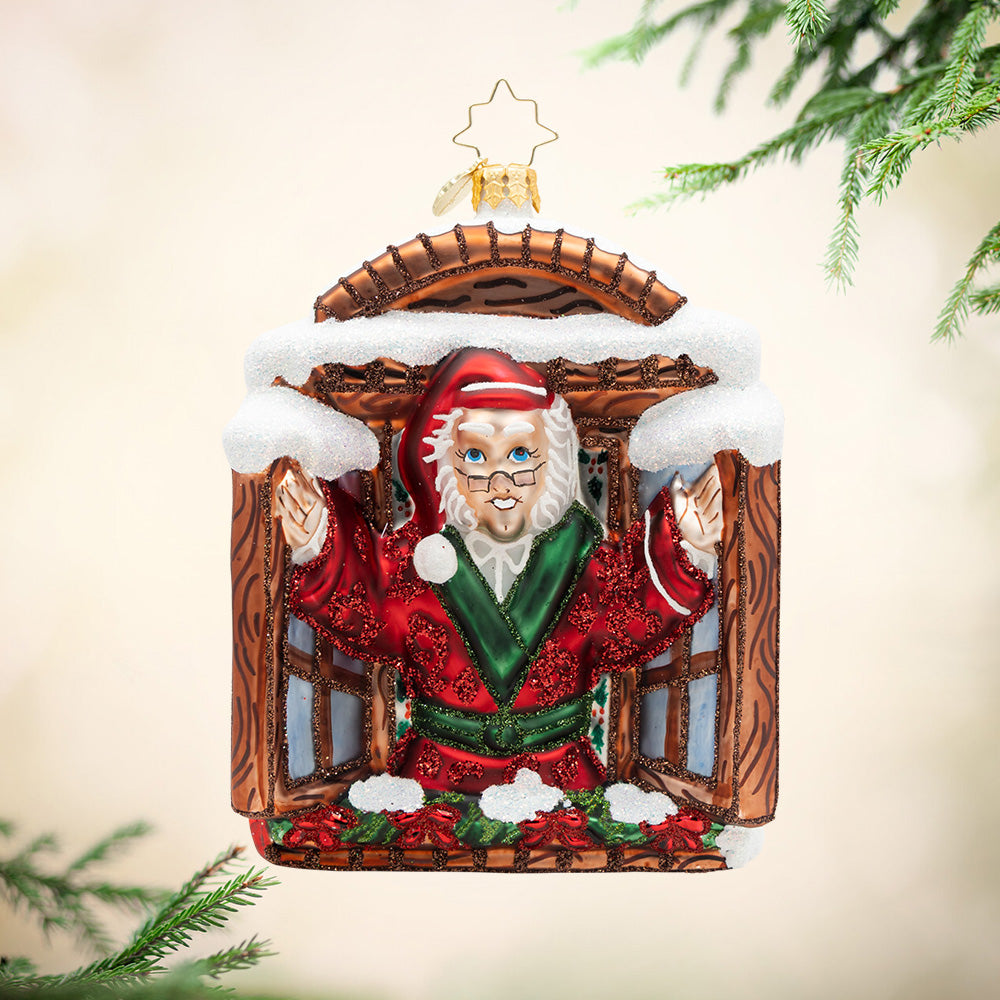 A New Day for Scrooge. Ornament of Mr. Scrooge in a red robe standing in a brown wooden window. View of front
