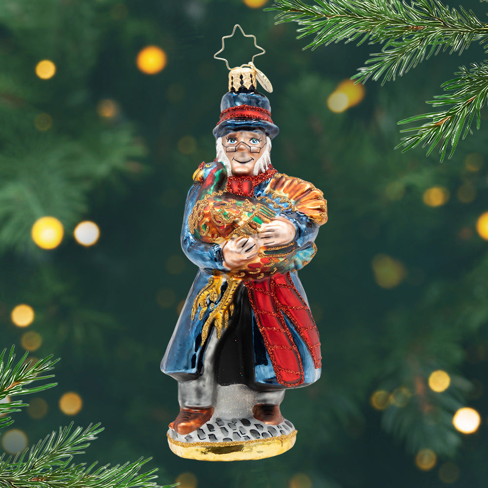 A Turkey for Tiny Tim. An ornament of Mr. Scrooge in a blue coat and holding a golden turkey. View of front.