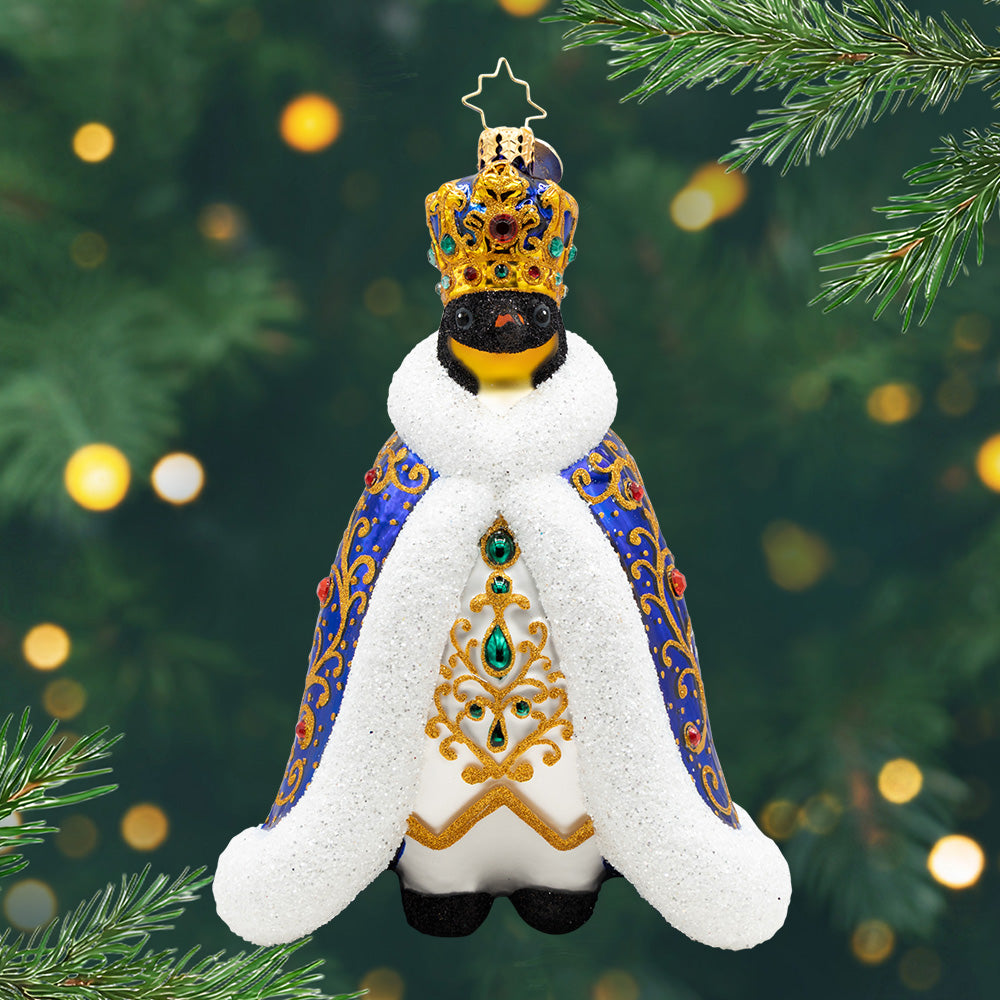 Emperor of the North. An ornament of a penguin in a blue robe with gold detailing and gems with a matching crown. View of front