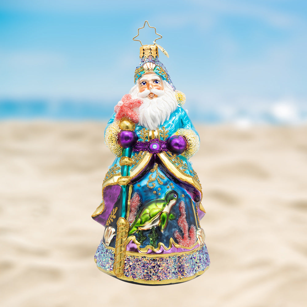 Santa of the Sea. Ornament of Santa in a blue and golden detailed robe with an underwater scene and a turtle painted in the front and holding a blue staff. View of front