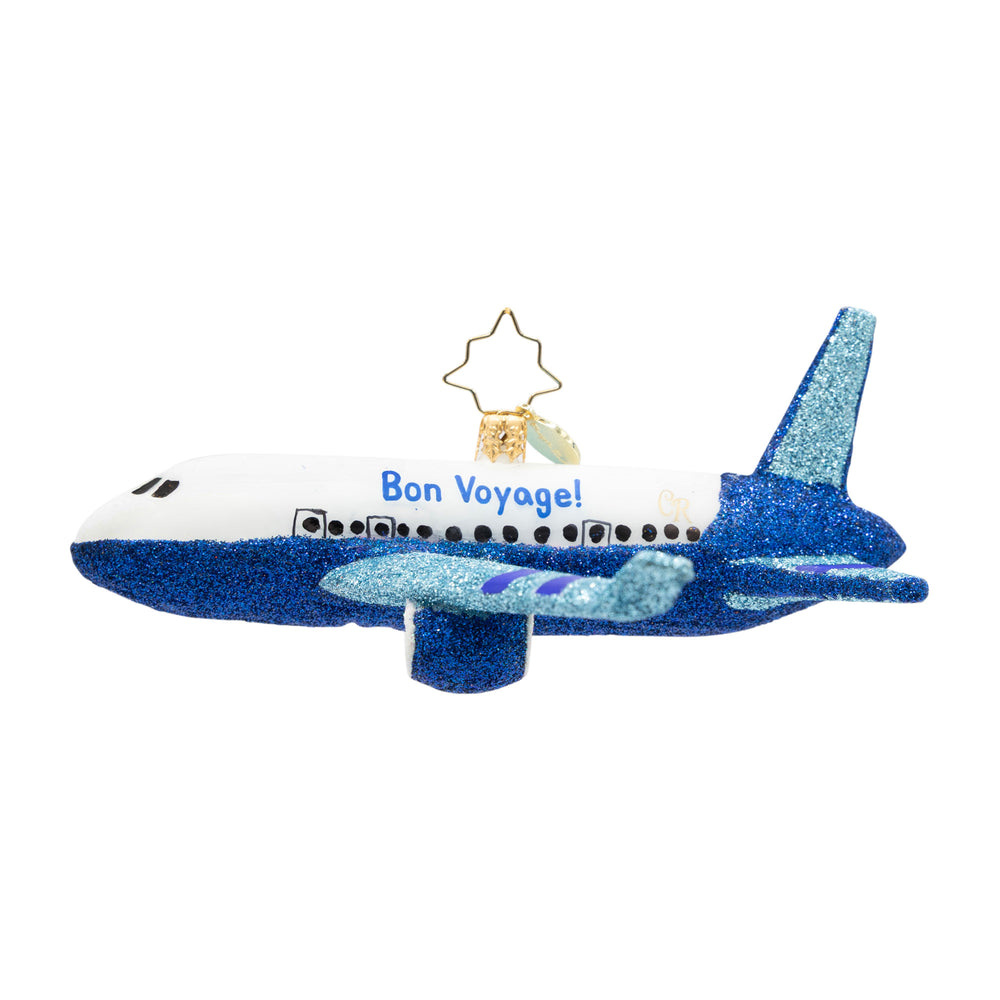 Blue glittery airplane ornament with 'Bon Voyage!' text on a white background