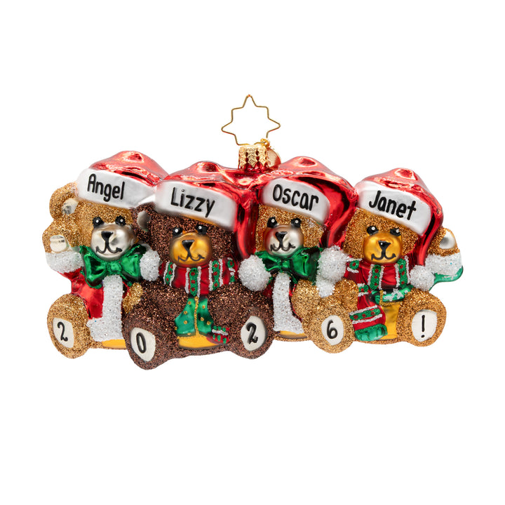 A personalized Christmas ornament featuring four glittery teddy bears wearing red Santa hats with names printed on them: Angel, Lizzy, Oscar, and Janet. Each bear holds a gold number, and the bears are decorated with green and red striped scarves.