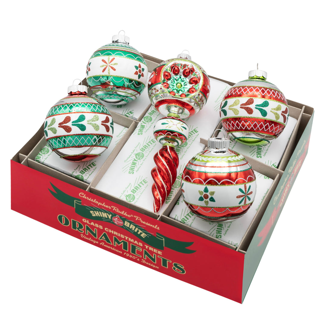 HOLIDAY SPLENDOR 5 COUNT 3.25” DECORATED ROUNDS & 7” SHAPE. Four silver round ornaments with colors and designs in red, teal, and green, along with a round ornament on top of an icicle shape with the same color range.
