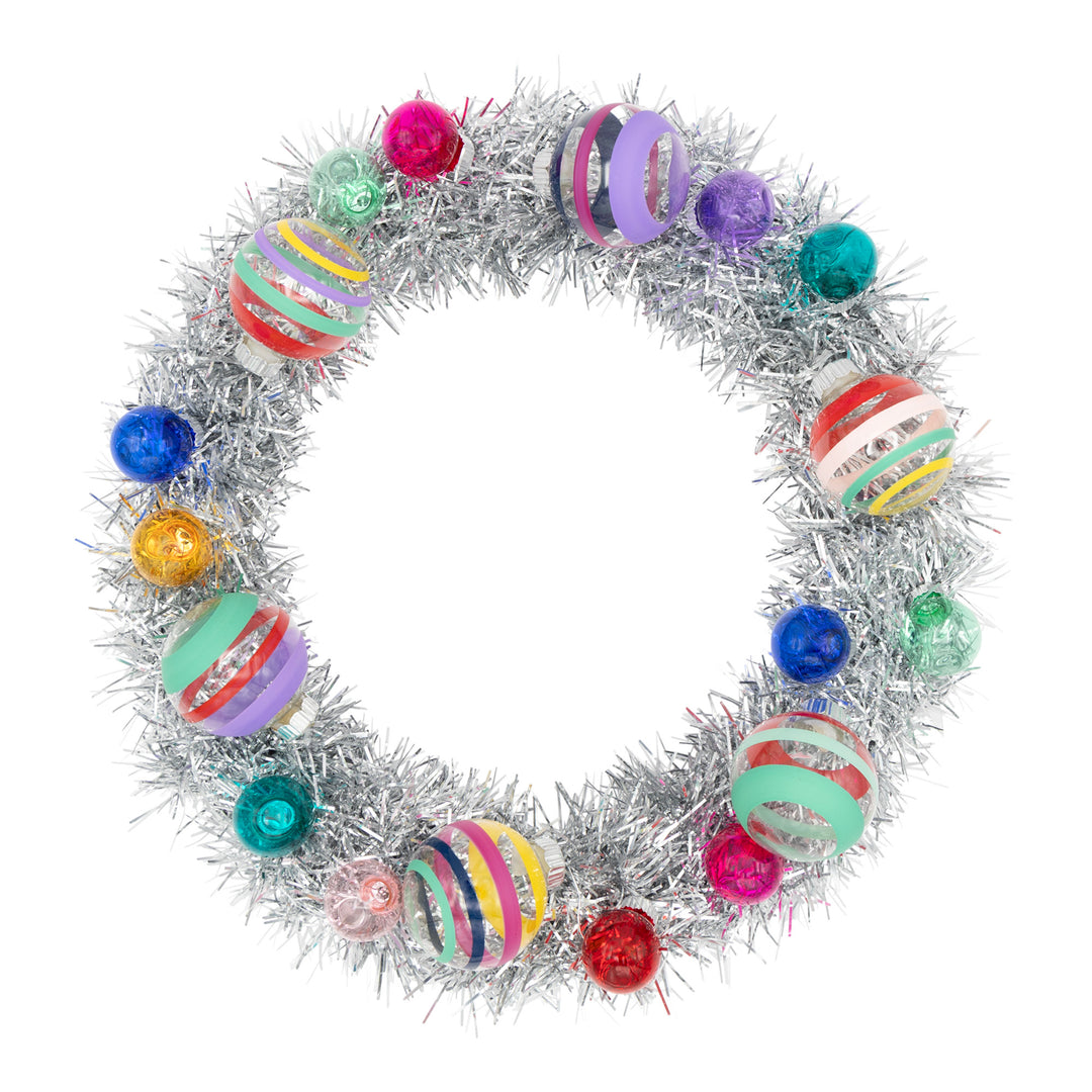 VIVID VINTAGE SILVER TINSEL WREATH WITH 1" AND 1.75" ROUNDS. Tinsel wreath with pink, purple, blue, red, green ornaments and clear stripped ornaments. View of front