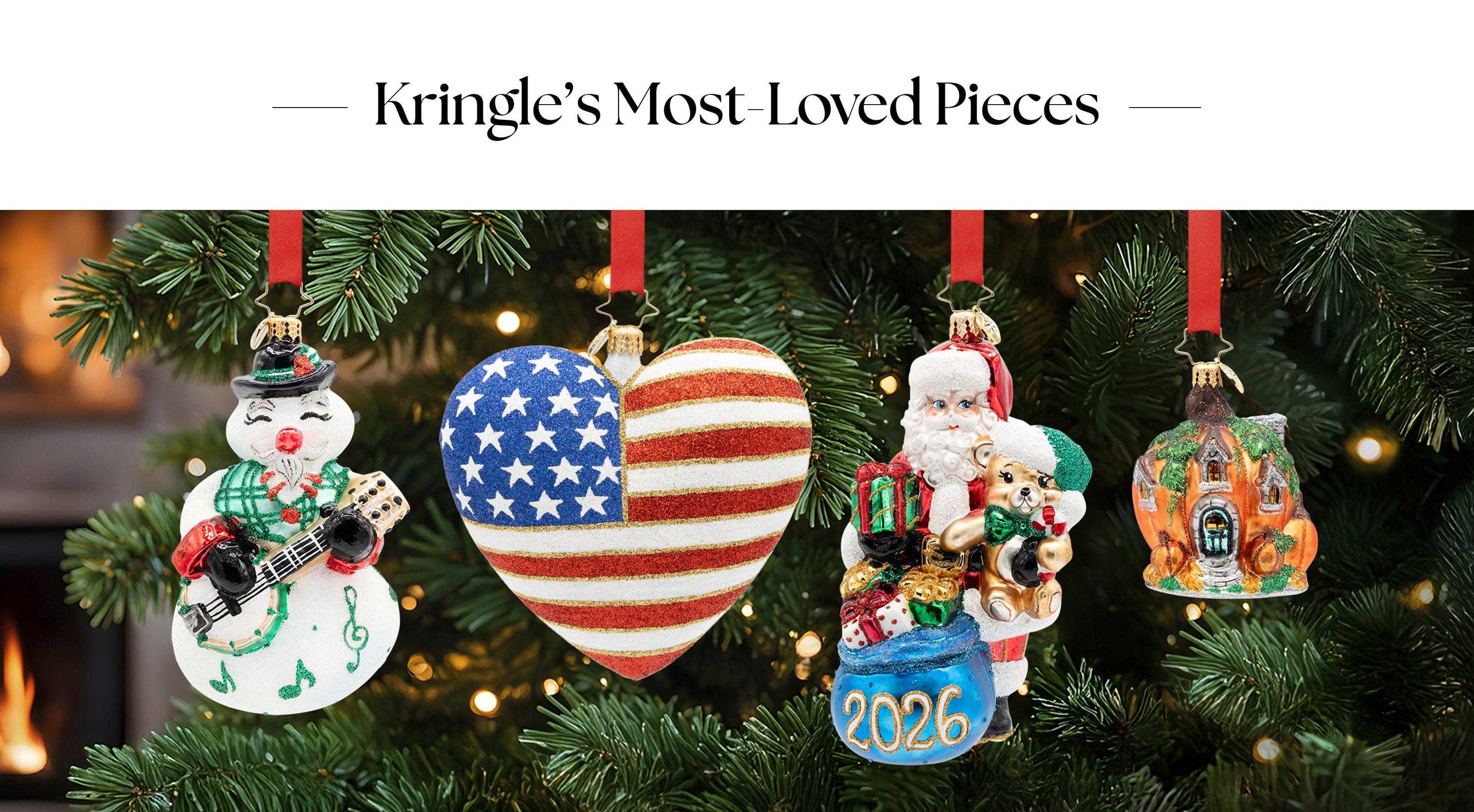 A banner collection of glass Christmas ornaments hanging on a decorated tree, including a musical snowman, American flag heart, 2026 Santa with gifts, and a pumpkin house.