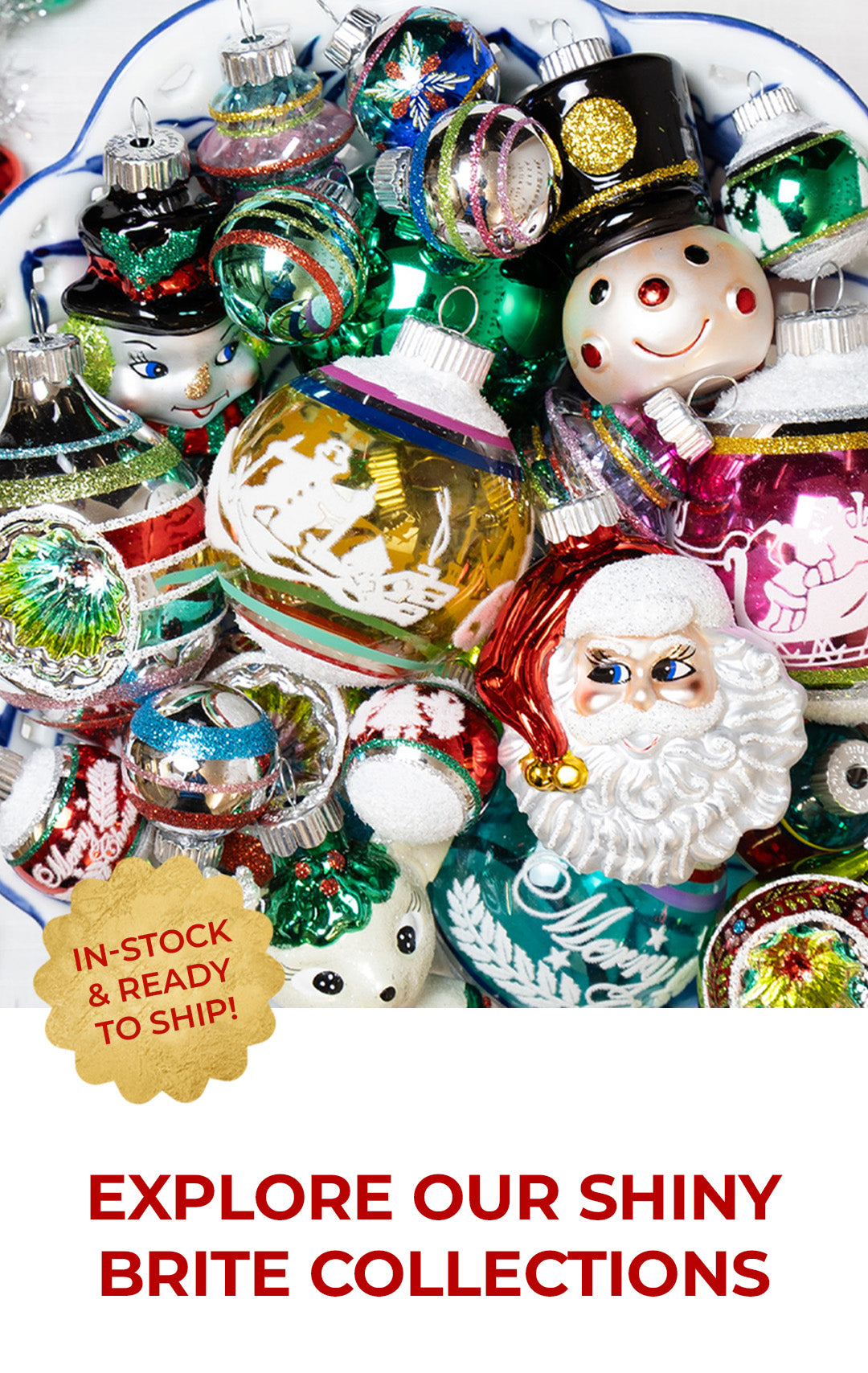 A colorful collection of vintage-style Shiny Brite Christmas ornaments piled in a decorative bowl, featuring Santa, snowman, and character figurines alongside glittery glass balls in red, green, gold, and pink.