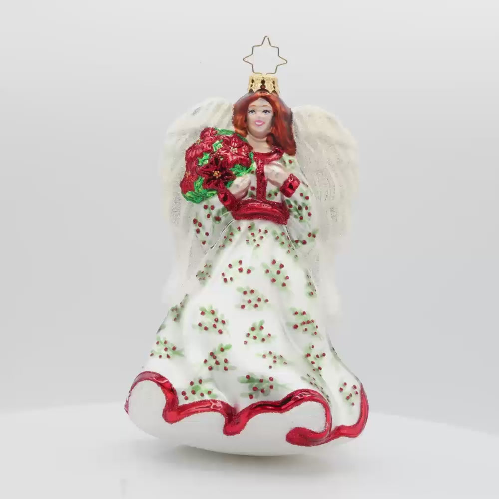Angelic Poinsettia Herald ornament. Features an angel wearing a flowing hand-painted gown holding a poinsettia bouquet. Video.