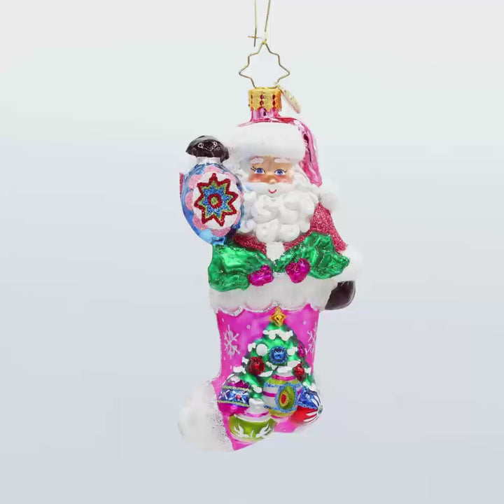 Santa's Stocking Stuffer ornament. Santa wears a shimmering pink suit and glittery hat. A colorful assortment of shiny brite ornaments adorn the stocking. Video.