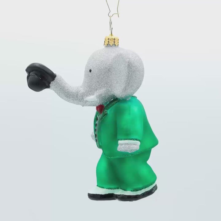 King Babar ornament. Babar dons his green suit, holding a top hat with his trunk. Video.