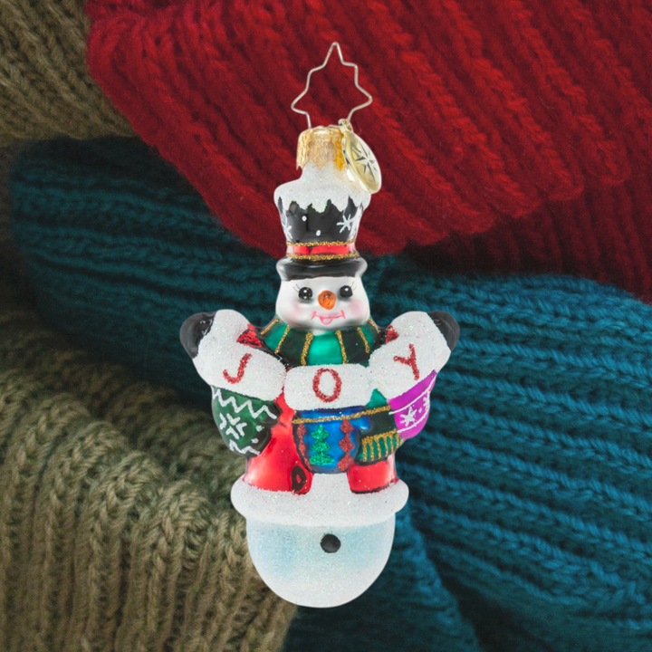 Ornament Description - Crochet All Day Gem: This little snowman has been hard at work with his crochet needles! He's proud as punch to show off his heartfelt, hand-made holiday message.